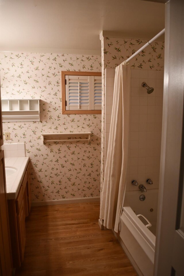 bathroom featuring hardwood / wood-style floors, shower / bath combo with shower curtain, and vanity