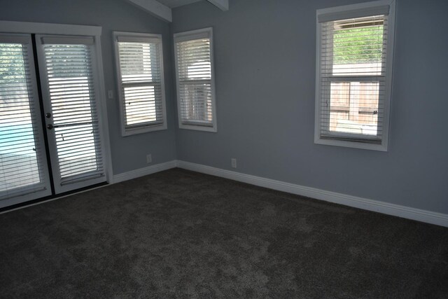 spare room featuring carpet flooring and lofted ceiling