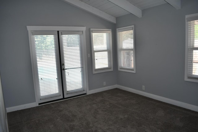 empty room featuring dark colored carpet, a healthy amount of sunlight, and lofted ceiling with beams