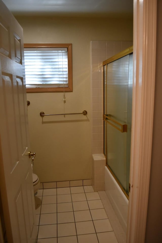 bathroom featuring shower / bath combination with glass door, toilet, and tile patterned floors