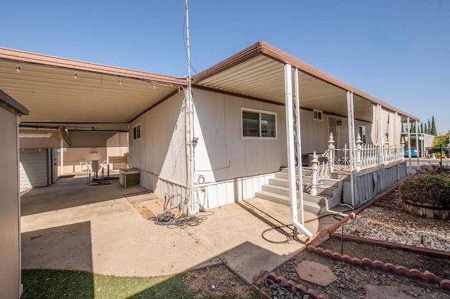 rear view of house featuring a carport and covered porch