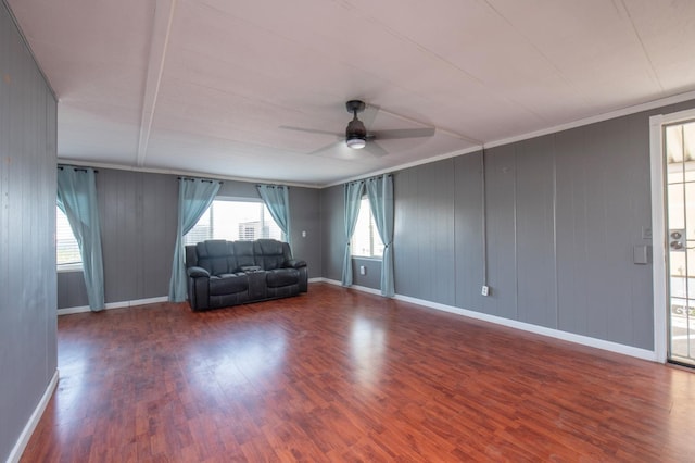 unfurnished living room with baseboards, wood finished floors, and a ceiling fan