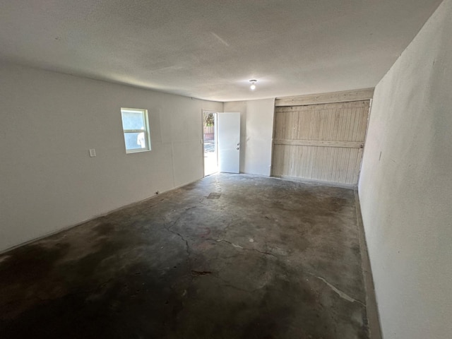 interior space with a textured ceiling and concrete floors