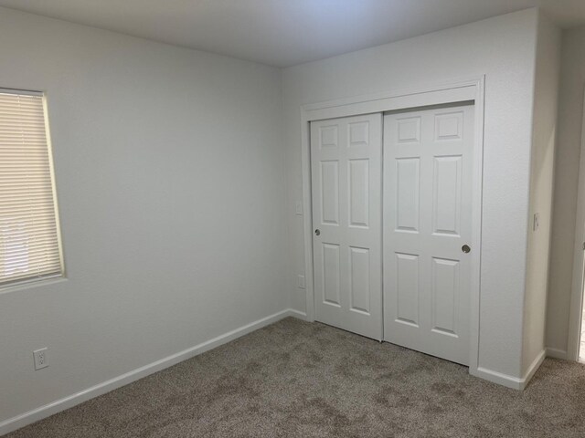 unfurnished bedroom with a closet and carpet