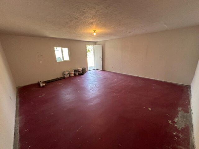 empty room with concrete floors and a textured ceiling