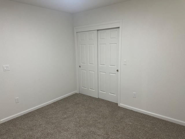 unfurnished bedroom with a closet and carpet flooring