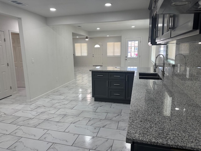 kitchen with sink, light tile patterned floors, backsplash, and stone counters