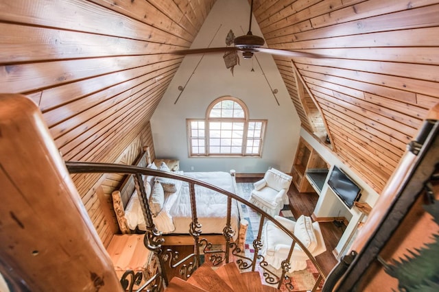 stairway with lofted ceiling, ceiling fan, hardwood / wood-style flooring, and wooden ceiling