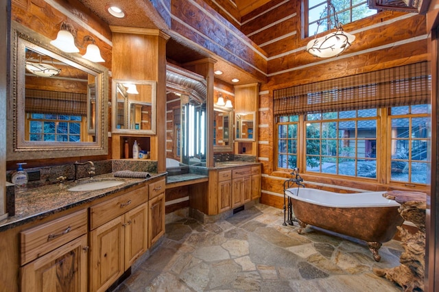 bathroom featuring vanity, a bath, wood walls, and tile patterned floors