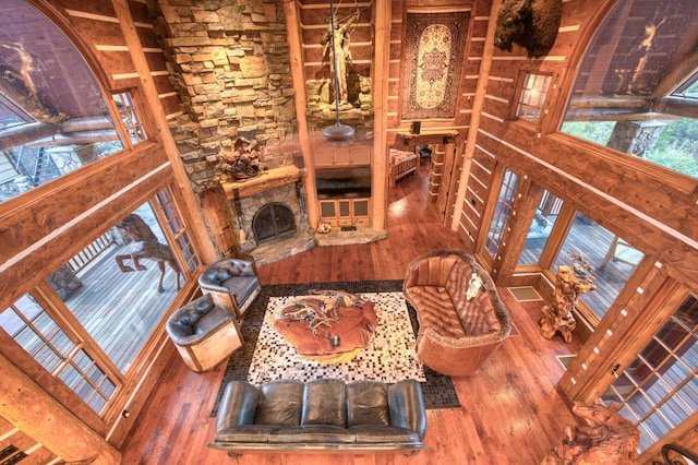 living room with hardwood / wood-style floors and a stone fireplace