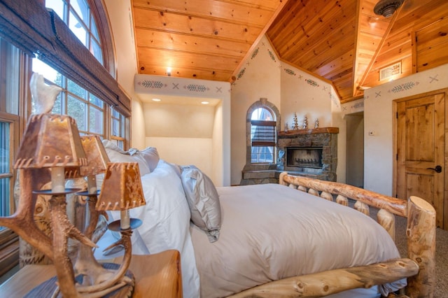 bedroom with wooden ceiling, multiple windows, high vaulted ceiling, and a stone fireplace