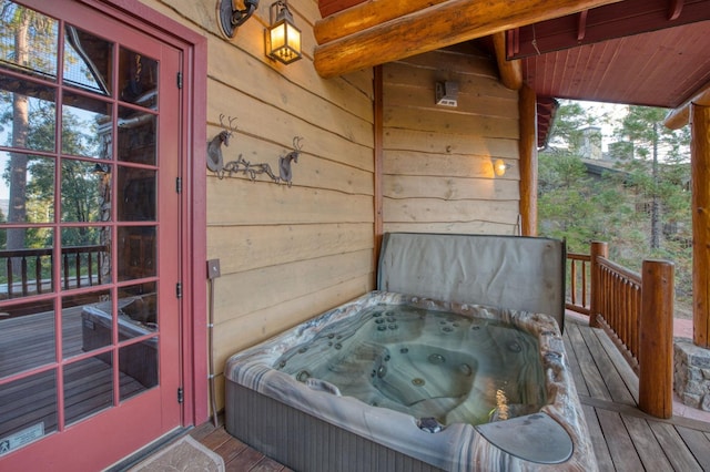 wooden deck with a hot tub and french doors