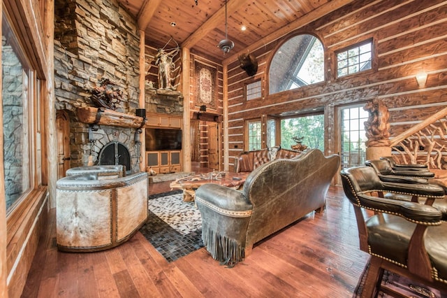 living room featuring beamed ceiling, wooden ceiling, a fireplace, high vaulted ceiling, and hardwood / wood-style flooring