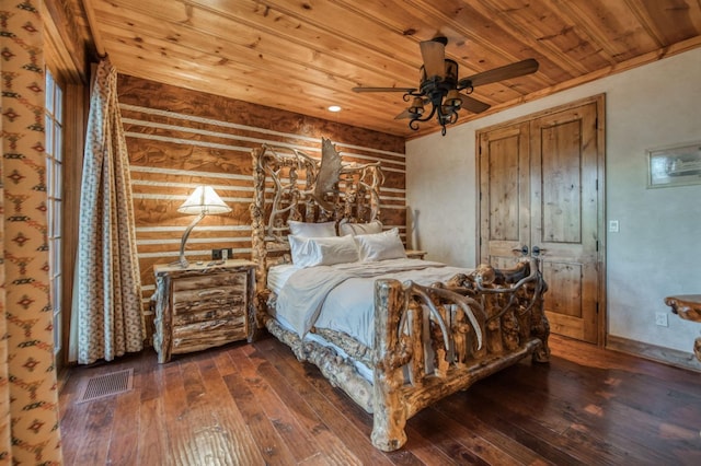 bedroom featuring wood ceiling, dark wood-type flooring, ceiling fan, and rustic walls