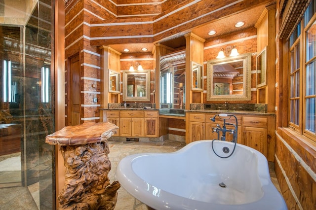 bathroom with tile patterned flooring, a washtub, wooden walls, and vanity