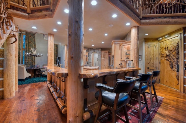 kitchen with wood-type flooring, a kitchen breakfast bar, and kitchen peninsula