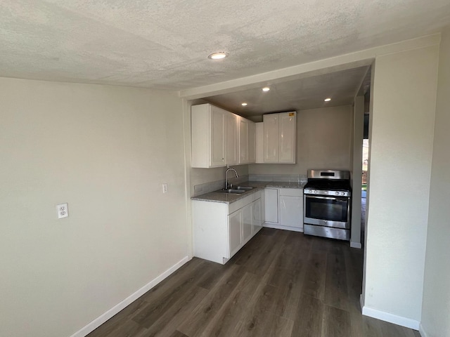 kitchen with stainless steel gas range, sink, white cabinetry, a textured ceiling, and dark hardwood / wood-style flooring