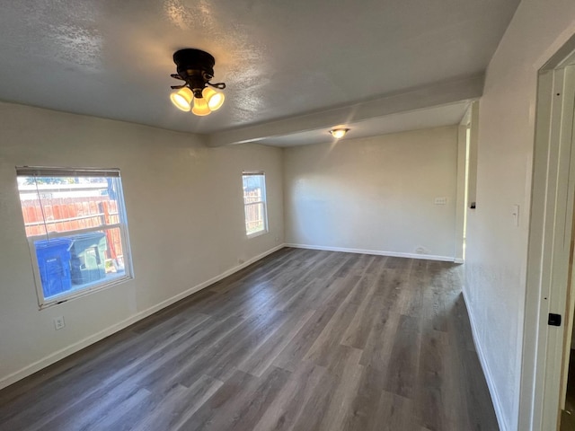 unfurnished room featuring dark hardwood / wood-style flooring and a textured ceiling