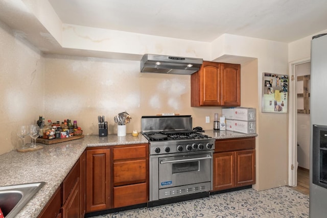 kitchen with sink, light tile patterned flooring, range hood, and luxury range