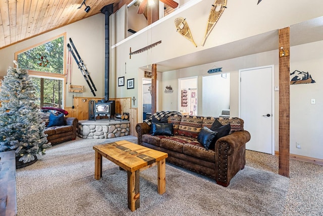 living room with a wood stove, carpet floors, wood ceiling, high vaulted ceiling, and ceiling fan