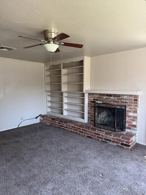 unfurnished living room featuring carpet flooring, a textured ceiling, ceiling fan, and a fireplace