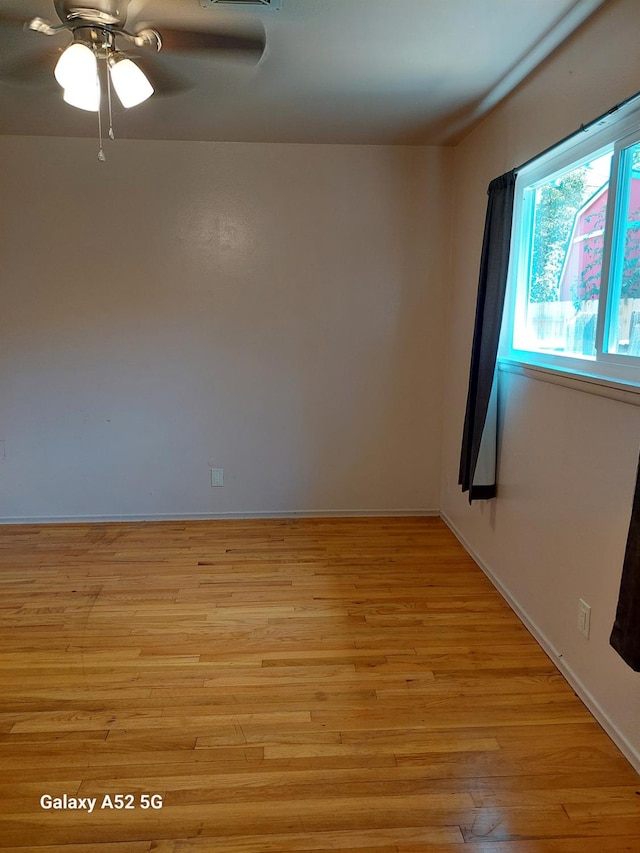 spare room featuring light wood-type flooring and ceiling fan