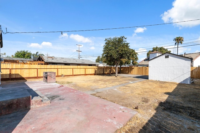 view of yard with a storage unit and a patio