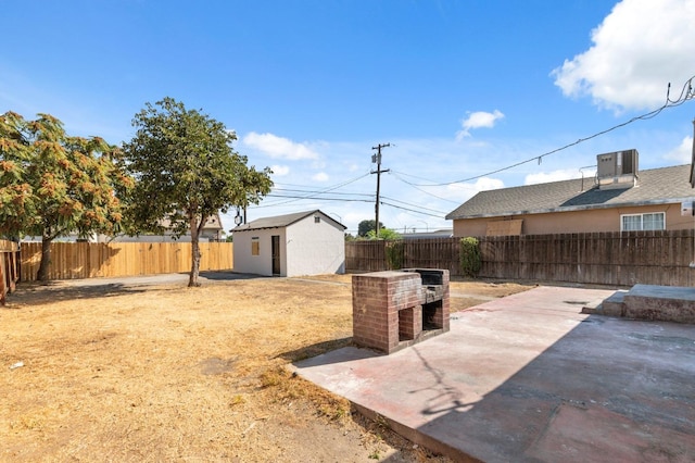 view of yard with a patio area, central AC, and a shed