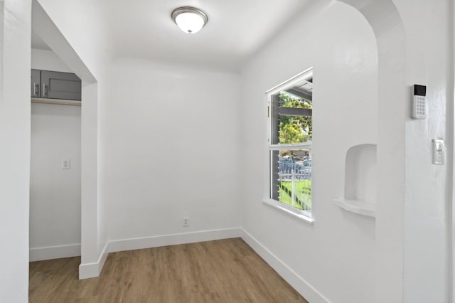 interior space with light wood-style floors, a wealth of natural light, and baseboards