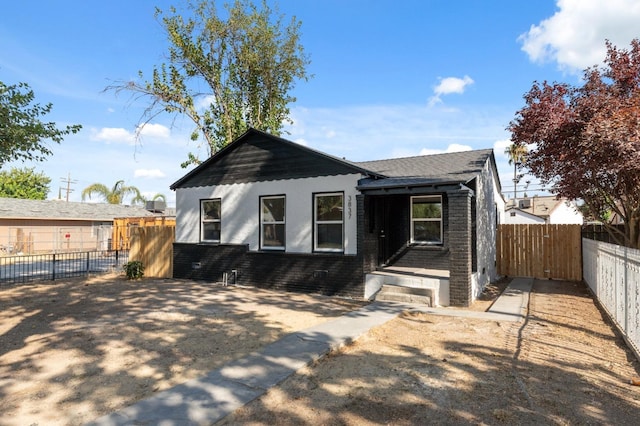 view of front of property with a fenced backyard and brick siding