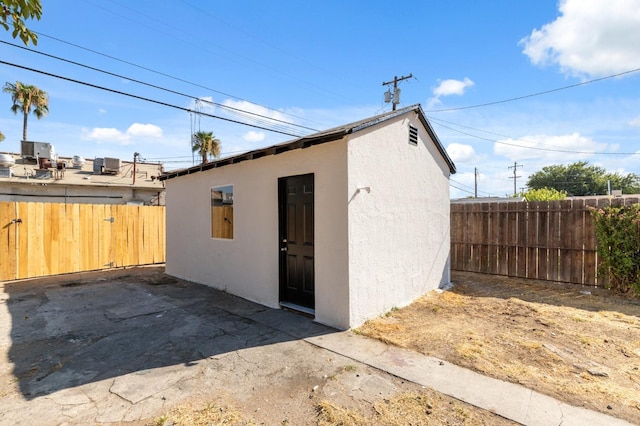 view of outbuilding featuring a fenced backyard, cooling unit, and an outbuilding