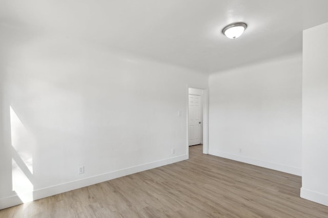 unfurnished room with baseboards and wood finished floors