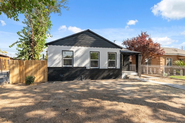 view of front of home with brick siding and fence