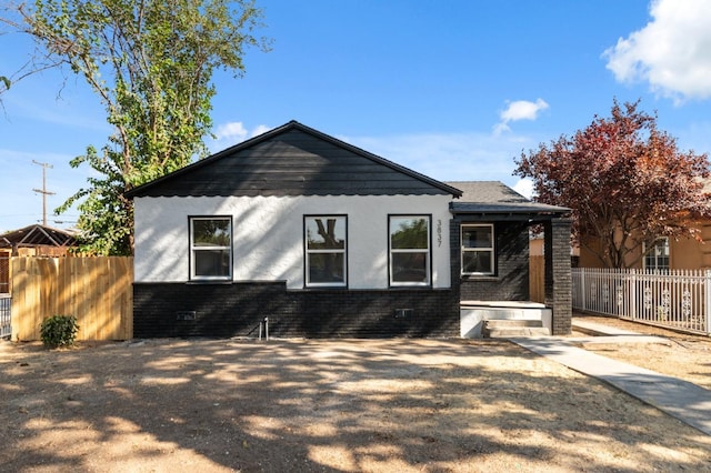 back of house with brick siding and fence