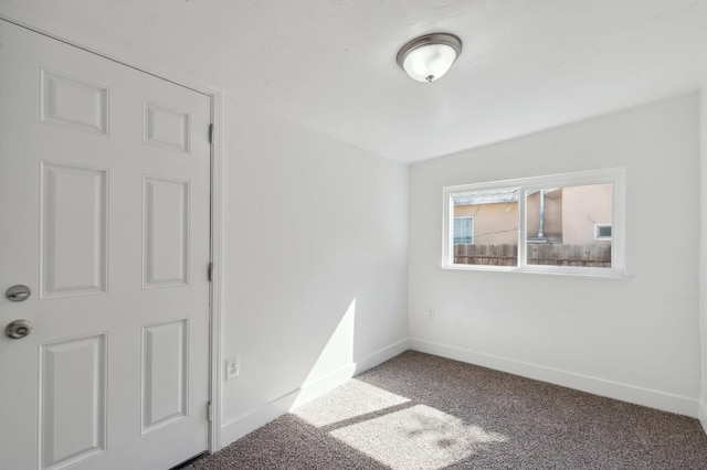 carpeted spare room with baseboards