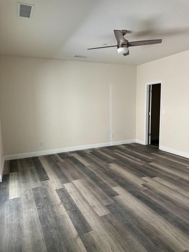 unfurnished room featuring dark wood-type flooring, ceiling fan, and a textured ceiling