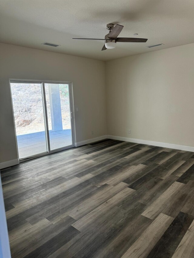 unfurnished room featuring dark wood-type flooring, ceiling fan, and a textured ceiling