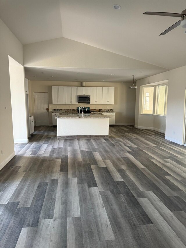 interior space with vaulted ceiling, ceiling fan, and dark hardwood / wood-style flooring