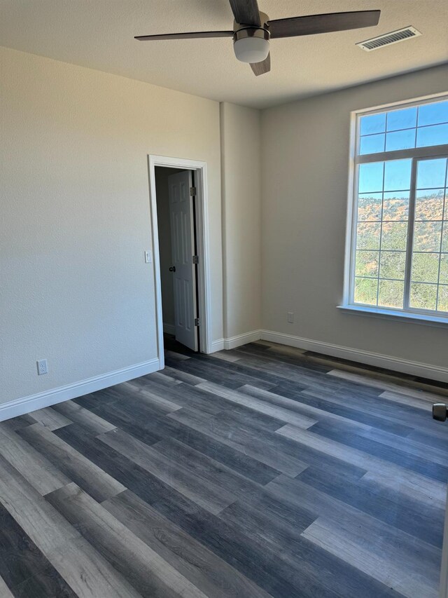 unfurnished room with ceiling fan and dark hardwood / wood-style floors