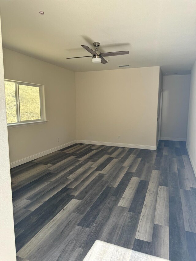 spare room featuring ceiling fan and dark hardwood / wood-style flooring