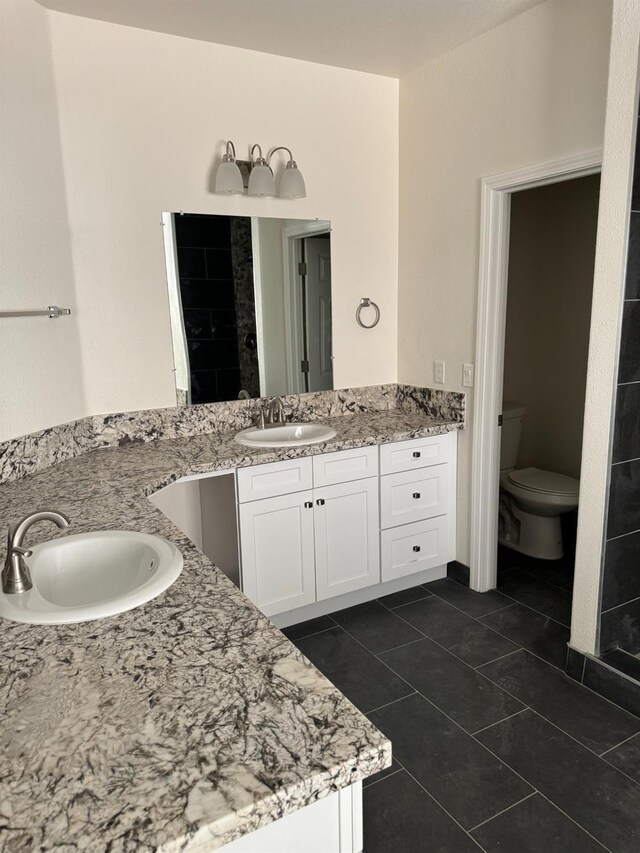 bathroom with tile patterned flooring, toilet, and vanity