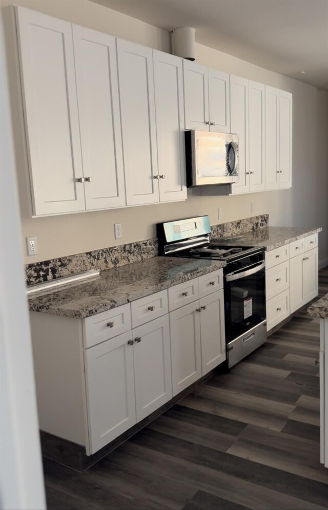 kitchen featuring dark hardwood / wood-style flooring, light stone countertops, appliances with stainless steel finishes, and white cabinets