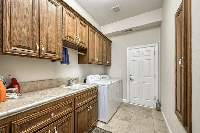 washroom with light tile patterned floors, cabinets, sink, and independent washer and dryer