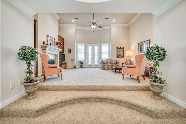 sitting room with ceiling fan, ornamental molding, and carpet floors