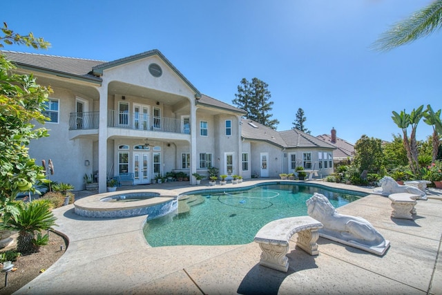 view of pool featuring a patio, an in ground hot tub, and french doors