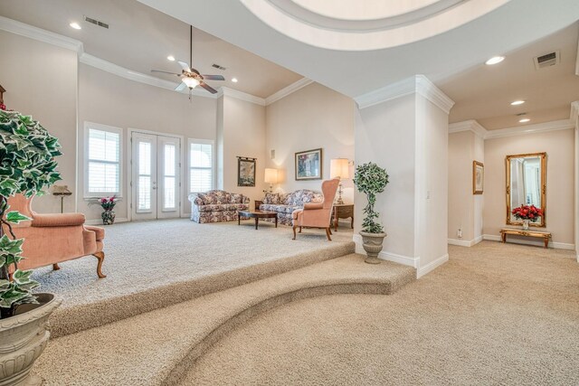 sitting room with light carpet, crown molding, a towering ceiling, and ceiling fan