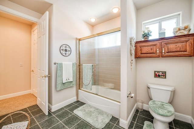 bathroom featuring tile patterned flooring, toilet, and combined bath / shower with glass door