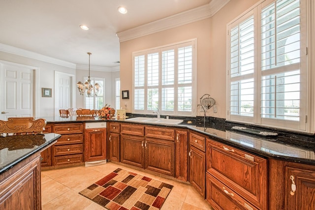 kitchen featuring a wealth of natural light, sink, decorative light fixtures, and an inviting chandelier