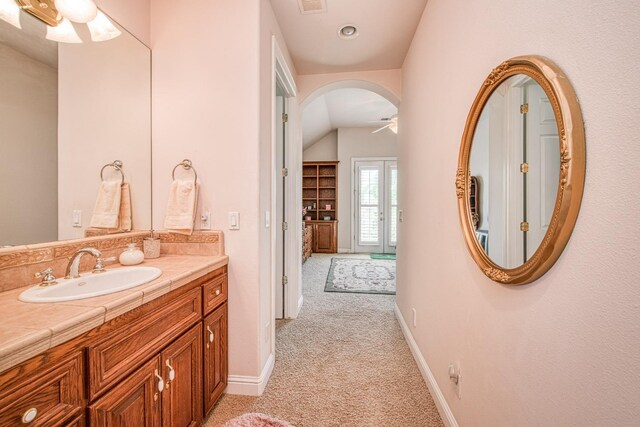 bathroom featuring ceiling fan, vaulted ceiling, and vanity