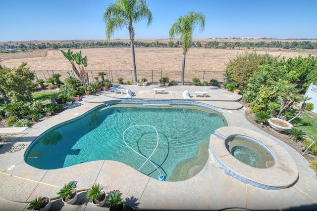 view of pool featuring an in ground hot tub, a rural view, and a patio